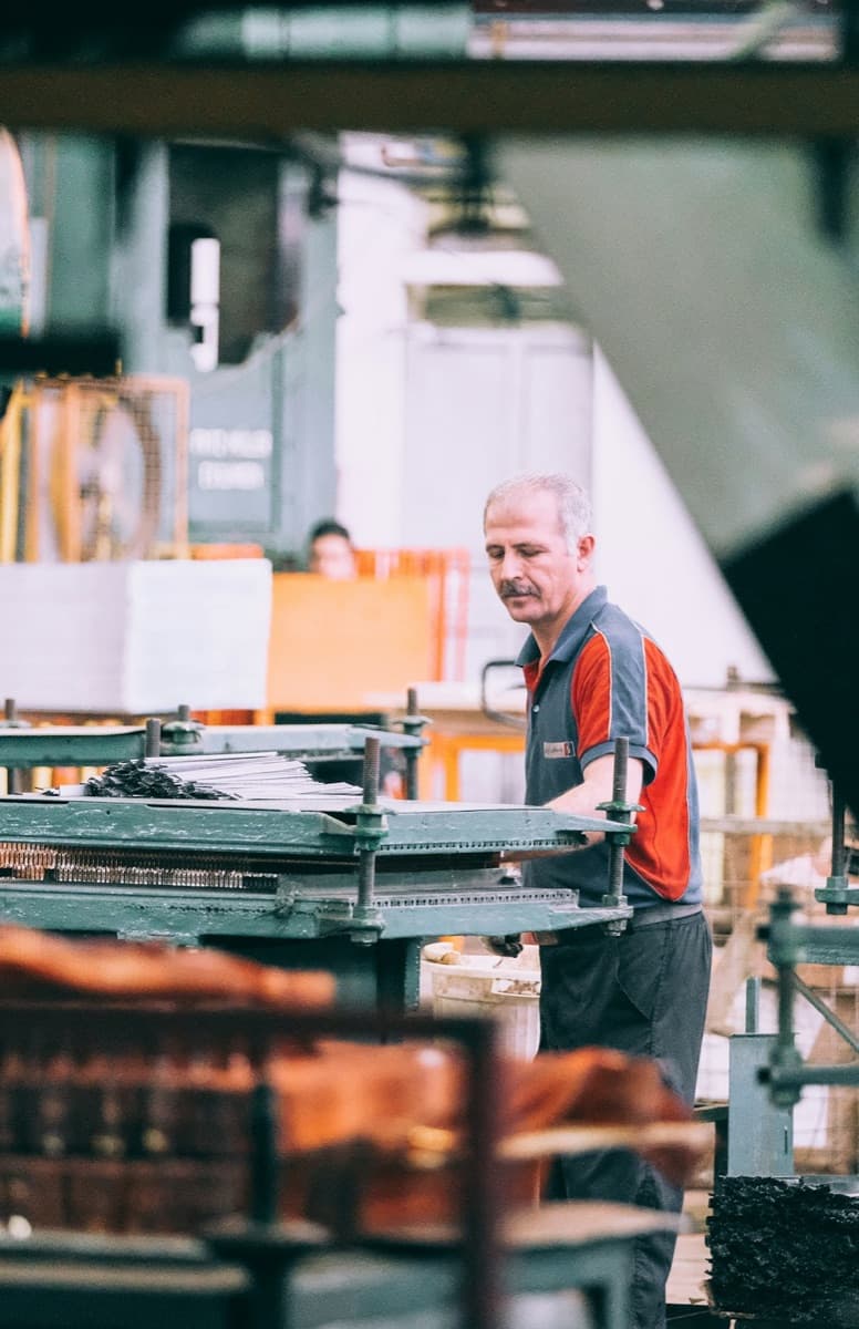 Machine operator working on industrial equipment in a factory
