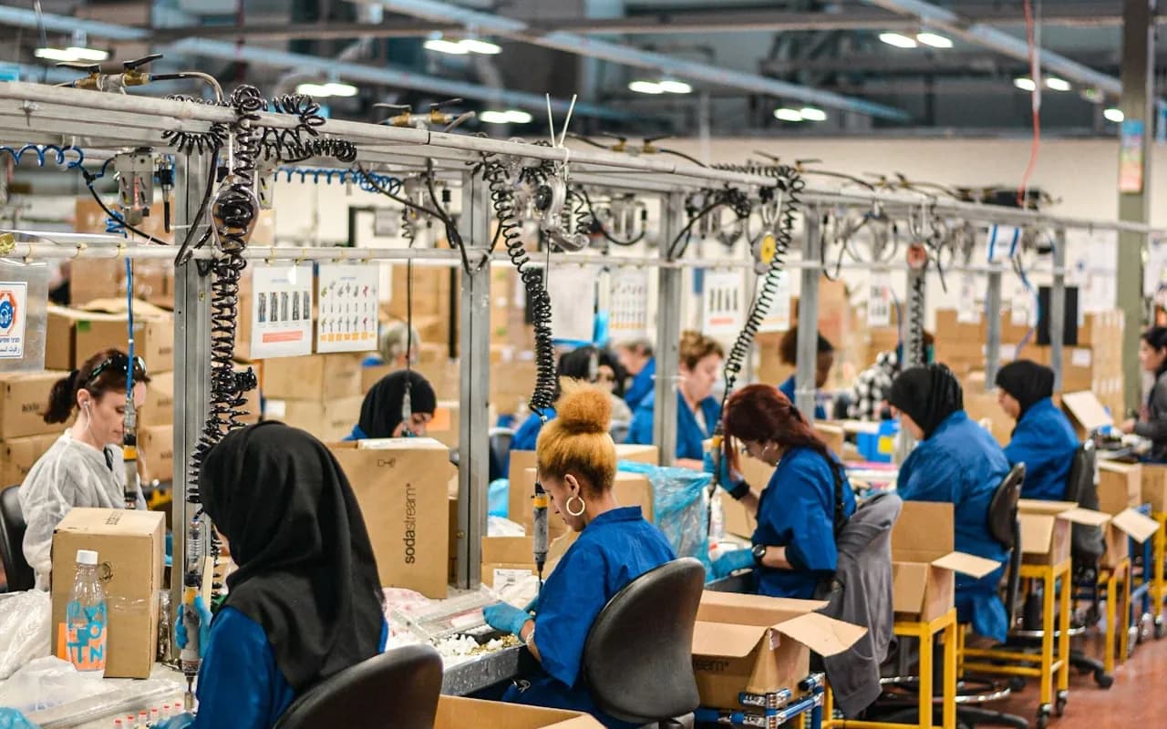 Production team working at an assembly line in a large plant