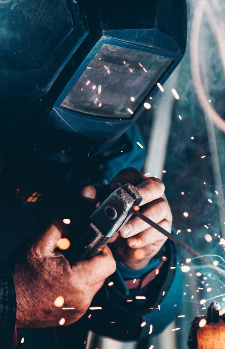 Welder grinding metal in an industrial workshop