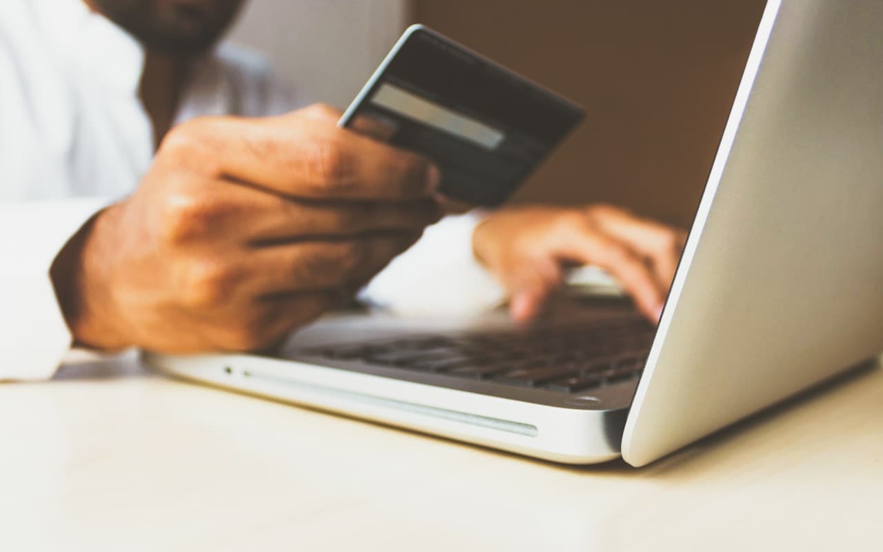 Customer paying by card on a laptop checkout