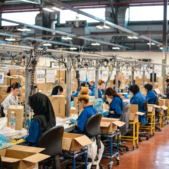 Production team working at an assembly line in a large plant