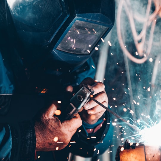 Welder grinding metal in an industrial workshop