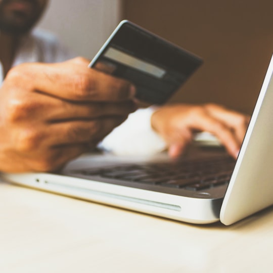 Customer paying by card on a laptop checkout